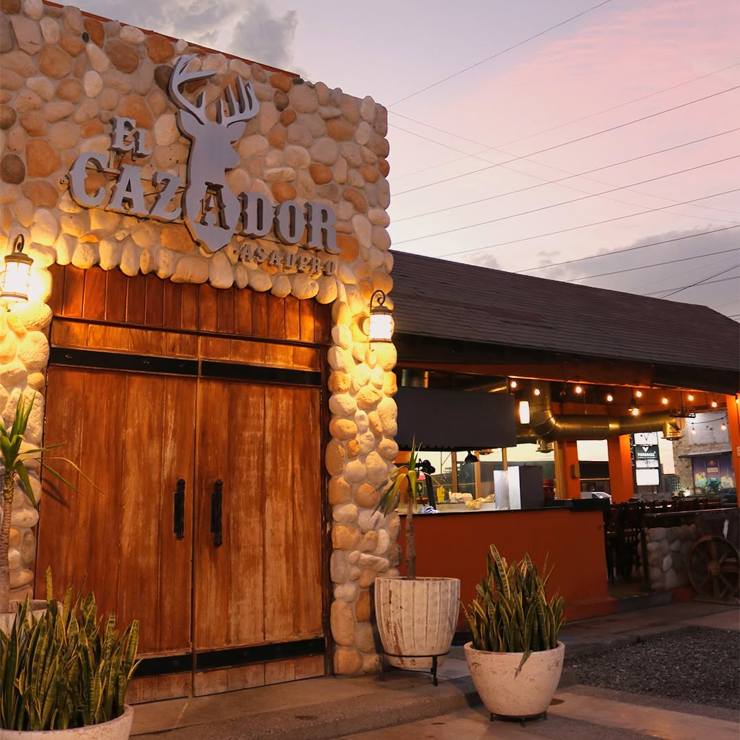 Entrada de El Cazador Asadero al atardecer